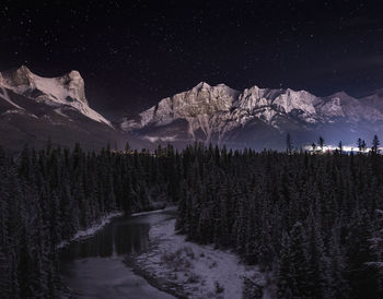 Scenic view of snowcapped mountains against sky at night