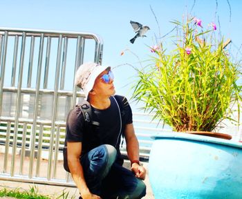 Young man sitting on plant