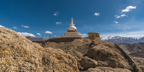 Low angle view of temple on mountain against blue sky