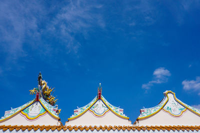 Low angle view of carousel against blue sky