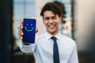 Portrait of smiling man holding smart phone