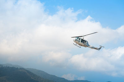 Low angle view of helicopter flying in sky