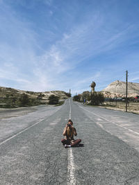 Rear view of woman on road against sky