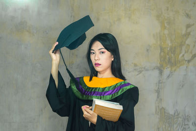 Portrait of beautiful woman standing against wall