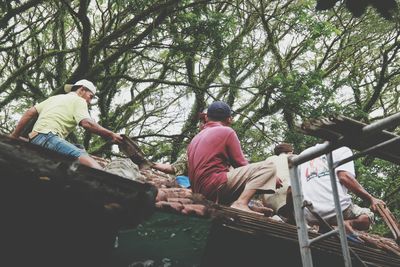 Rear view of people sitting in forest