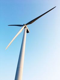 Low angle view of wind turbine against clear blue sky