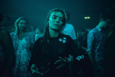 Young man and woman in illuminated nightclub