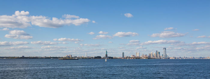 Sea by cityscape against sky