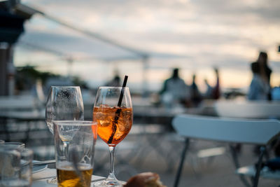 Wine glass on table at cafe against sky
