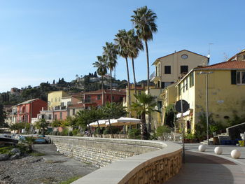 View of swimming pool by buildings against clear blue sky
