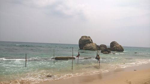 People on beach against sky