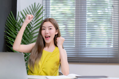 Portrait of smiling young woman using laptop