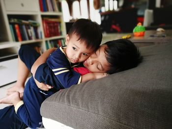 Brothers relaxing on sofa at home