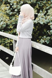 Rear view of woman standing by railing