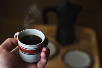 Cropped image of person holding coffee cup