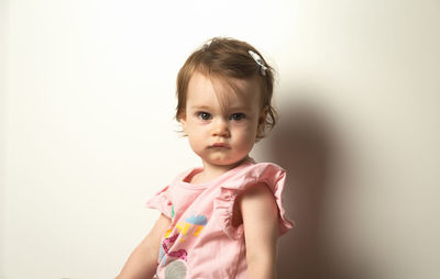 Portrait of cute girl holding camera over white background