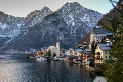 Town by mountain against sky during winter