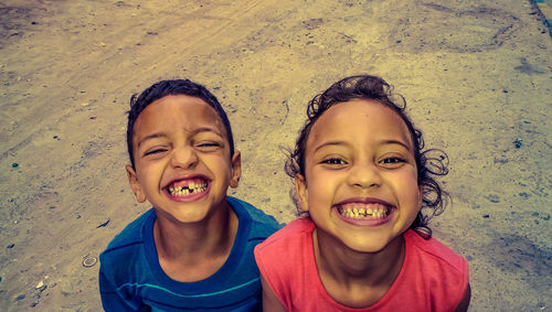 Portrait of smiling siblings standing on ground