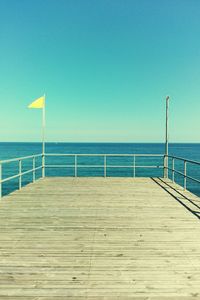 Scenic view of beach against clear blue sky