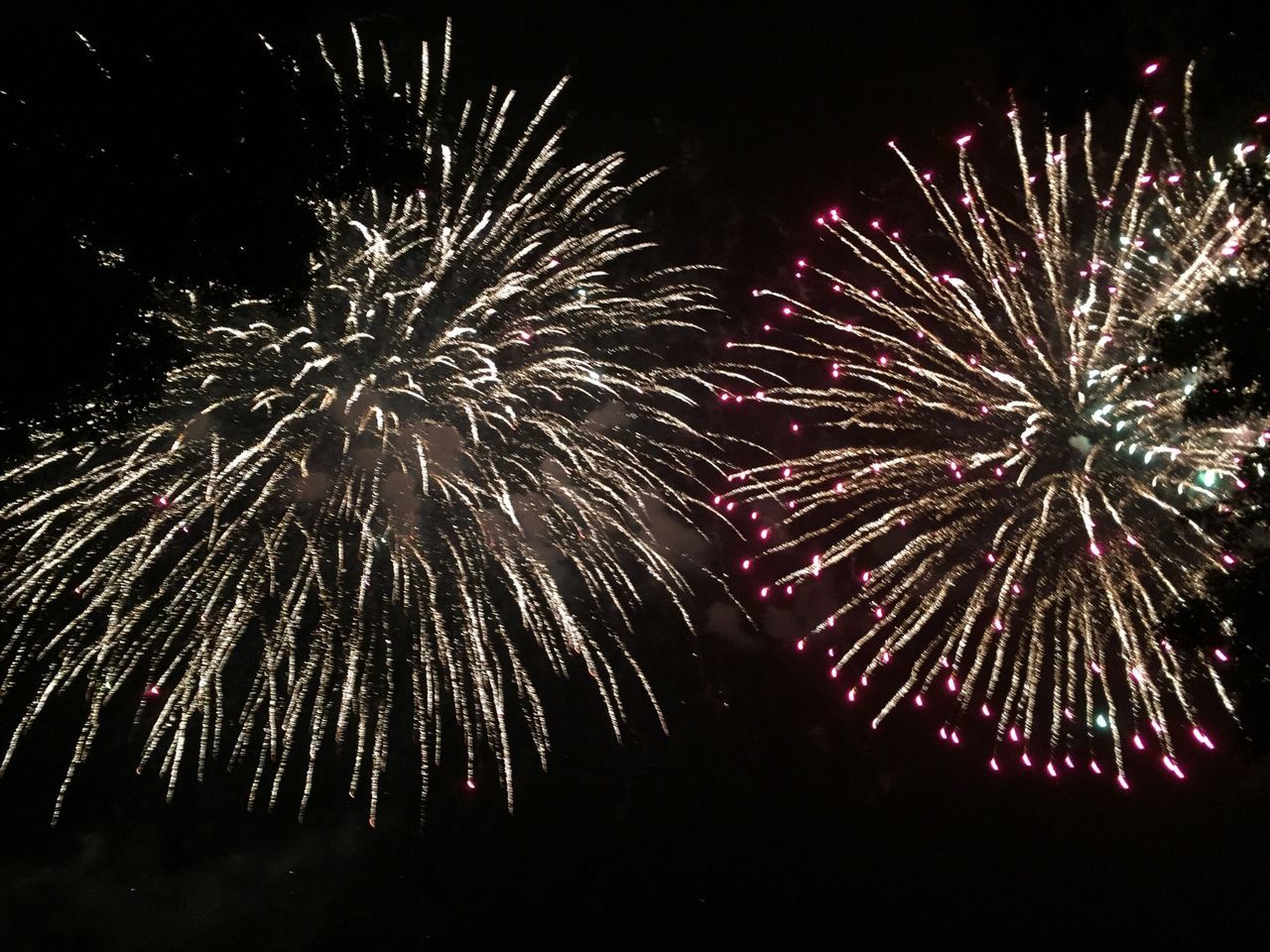 night, firework display, illuminated, celebration, exploding, firework - man made object, long exposure, arts culture and entertainment, event, motion, sparks, glowing, entertainment, firework, multi colored, low angle view, blurred motion, celebration event, sky, fire - natural phenomenon