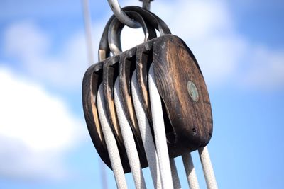 Low angle view of rigging hanging against sky