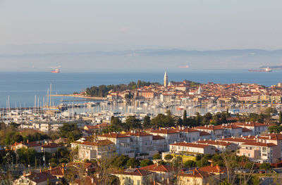 High angle view of townscape by sea against sky