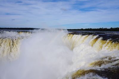 Scenic view of waterfall against sky