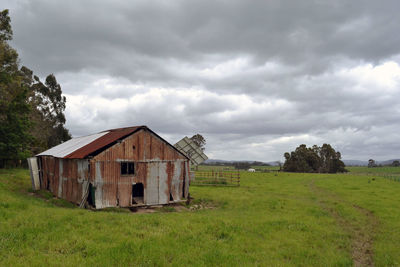 Abandoned house on field against sky