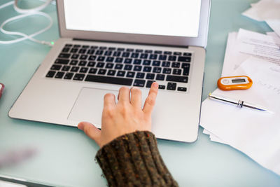 Close-up of woman using laptop on table