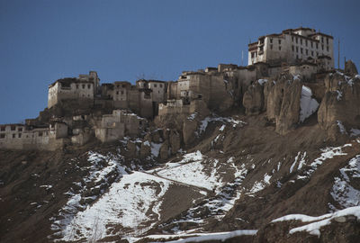 Buildings in city against clear blue sky