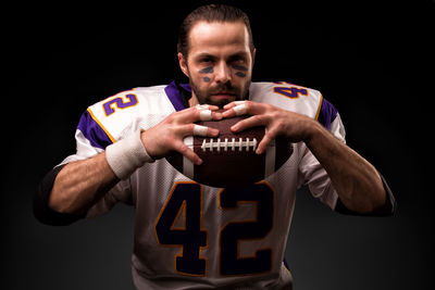 Portrait of man standing against black background