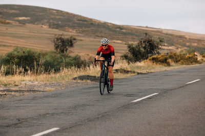 Rear view of man riding bicycle on road