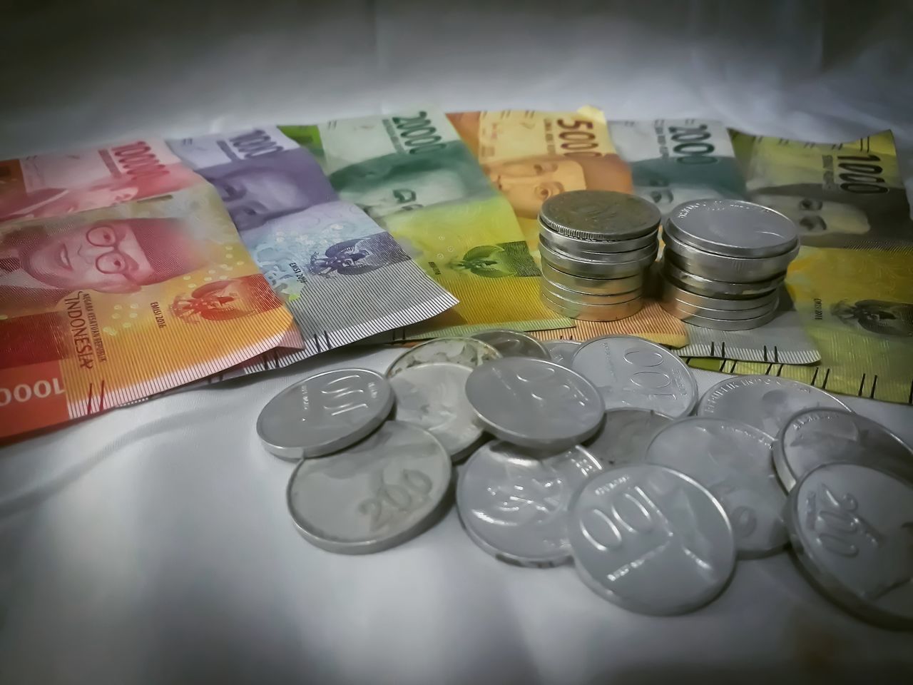 HIGH ANGLE VIEW OF COINS IN CONTAINER ON TABLE