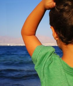 Close-up of boy against sea
