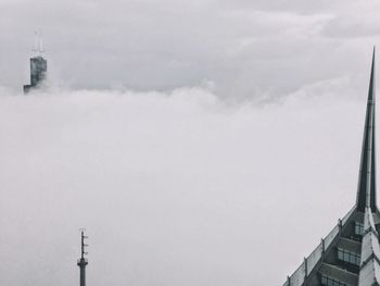 Tower amidst buildings against sky during winter