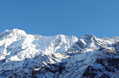 Scenic view of snowcapped mountains against clear blue sky