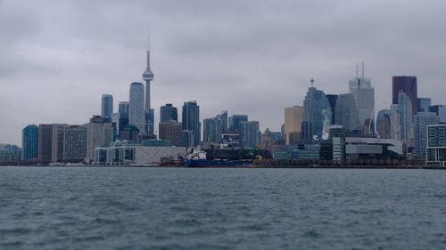 Modern buildings in city against cloudy sky