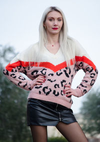 Portrait of beautiful young woman standing against white background