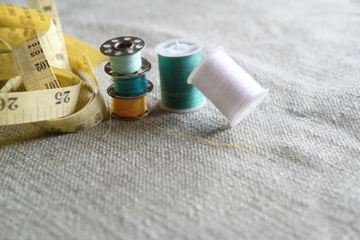 Close-up of threads and measure tape on table