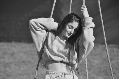 Rear view of young woman swinging at playground