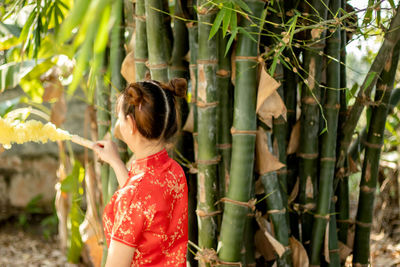 Side view of woman standing by plants