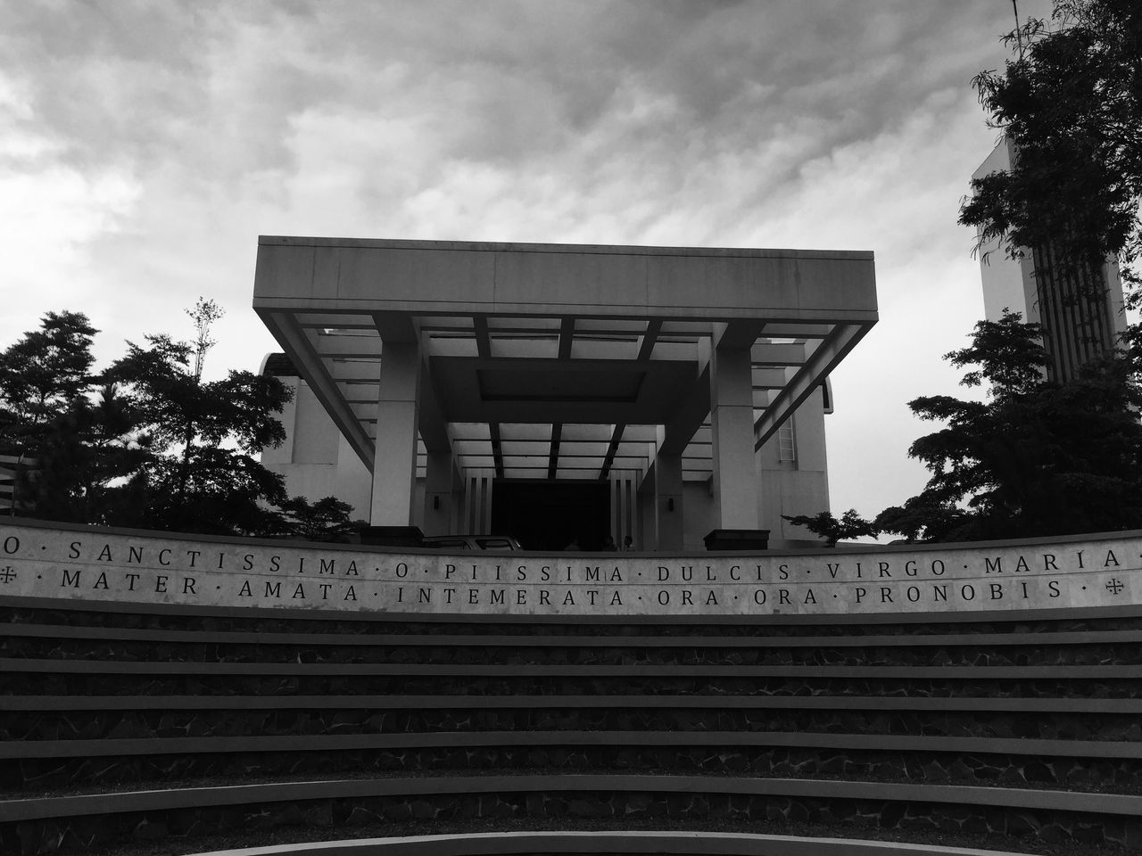 sky, low angle view, tree, railroad track, cloud - sky, built structure, steps, architecture, rail transportation, railing, cloud, cloudy, staircase, steps and staircases, day, building exterior, railroad station, outdoors, no people, text