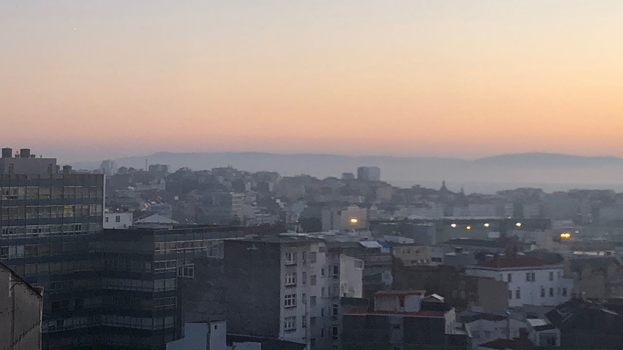 HIGH ANGLE VIEW OF TOWNSCAPE AGAINST ORANGE SKY