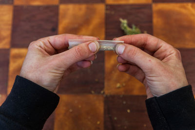 High angle view of person hand holding glass table