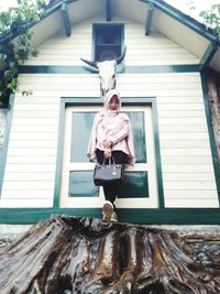 Full length of woman standing outside house