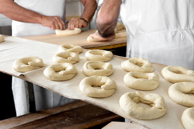 Midsection of men preparing food in kitchen