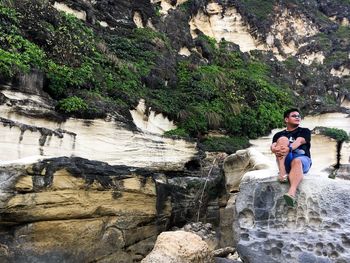 Full length of young woman standing on cliff