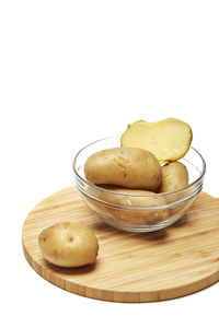 Close-up of bread in bowl on table against white background