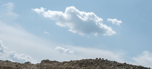 Low angle view of clouds over mountain against sky