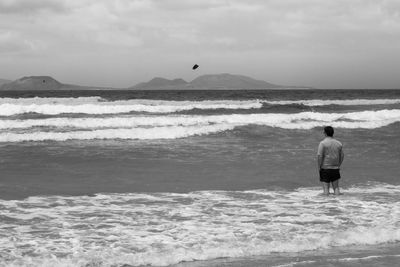 Rear view of man standing on beach